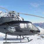 A helicopter flying over a snow covered mountain