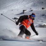A man riding skis down a snow covered slope