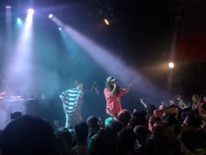 A group of people on a stage with a crowd watching