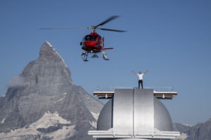 A helicopter flying over a snow covered mountain