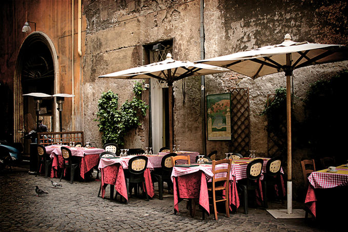 A group of people sitting at a table in front of a building