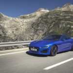 A blue car parked on the side of a mountain road