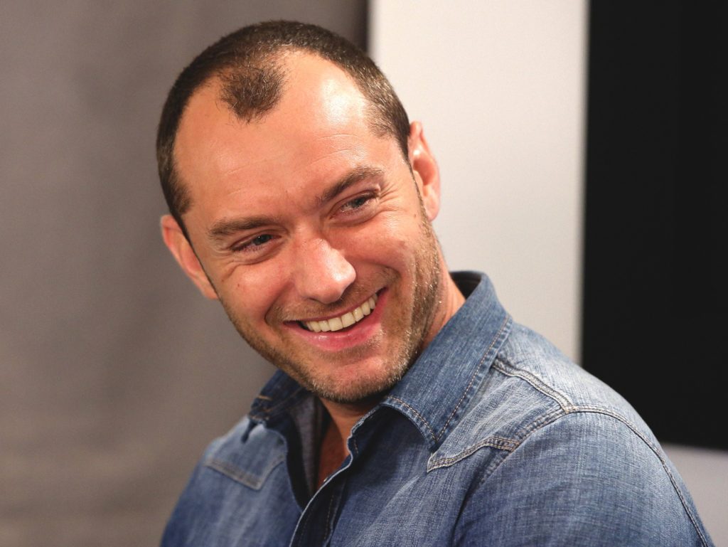 A man wearing glasses and smiling at the camera