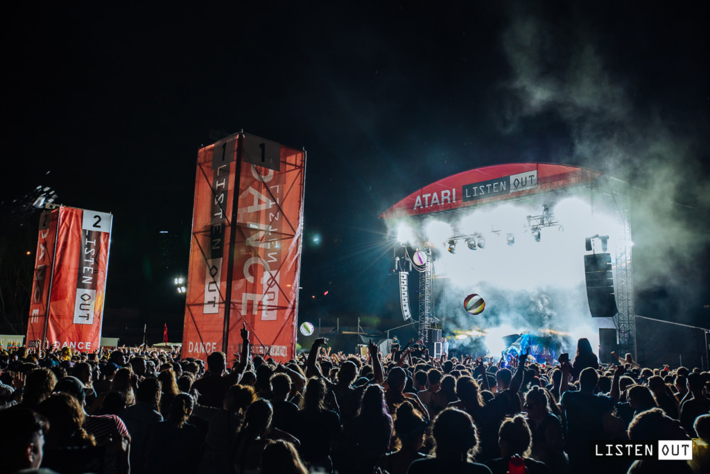 A group of people on a stage with a crowd watching