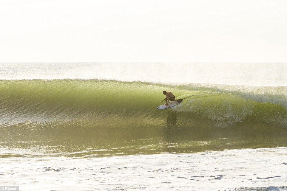 A man riding a wave on a surfboard in the ocean