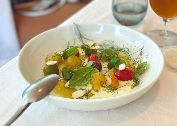 Warmed heirloom cherry tomatoes with rapeseed oil, stracciatella and young almonds.