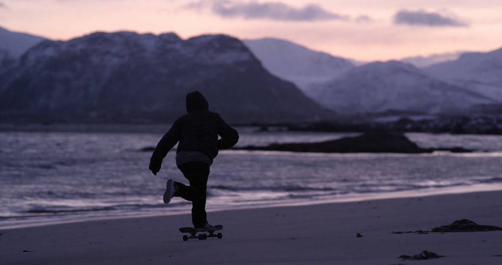 A man riding a snowboard down a snow covered mountain