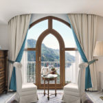 A bedroom with a bed and a chair in a room