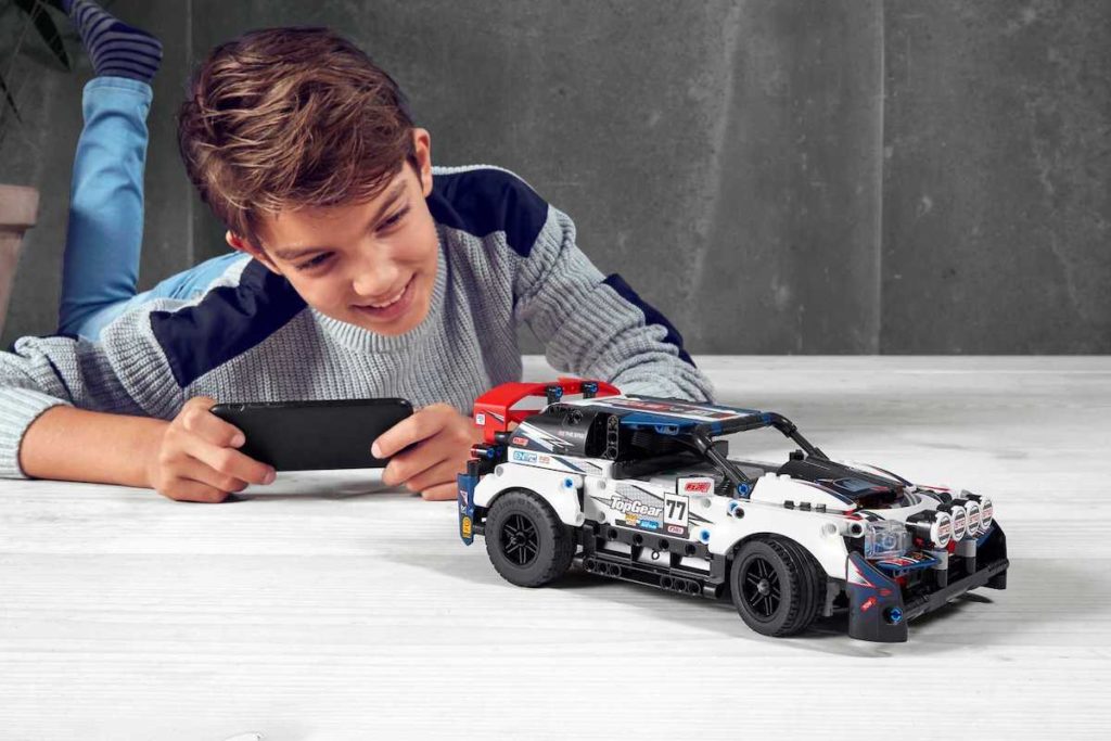 A young boy sitting on top of a car