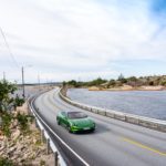 A car parked on the side of a road near a body of water