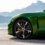 A green car parked on the side of a mountain