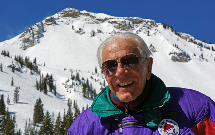 A man standing on top of a snow covered mountain