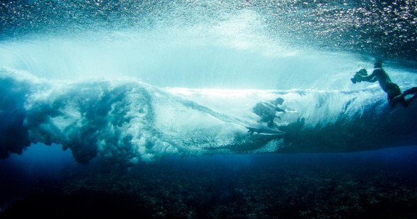 A man riding a wave on top of a body of water