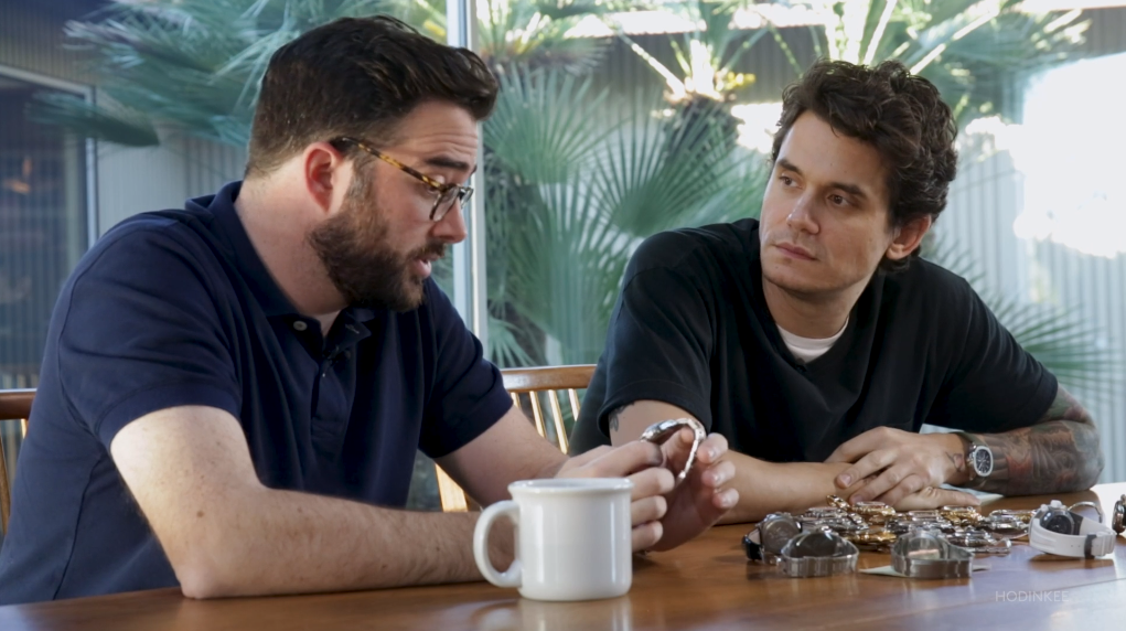 A man sitting at a table with a cup of coffee