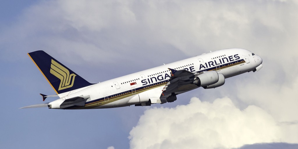 A large passenger jet flying through the air on a cloudy day