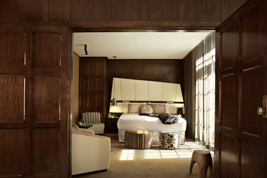 A kitchen with wooden cabinets and a bed in a room