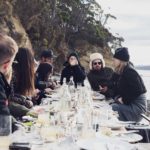 A group of people sitting at a table with wine glasses