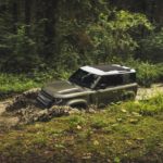A car parked on pavement near a forest