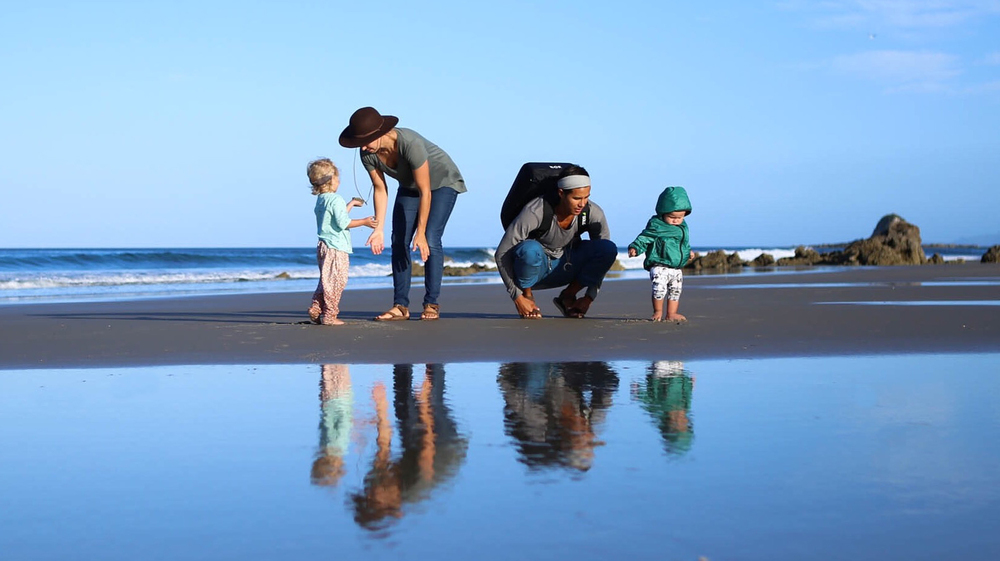 A group of people on a beach near a body of water