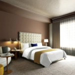 A bedroom with a bed and desk in a hotel room