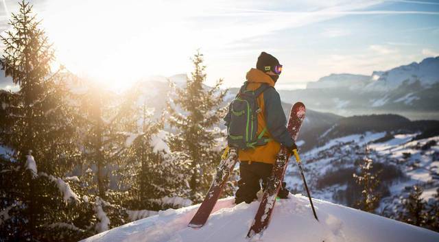 A man standing on top of a snow covered slope