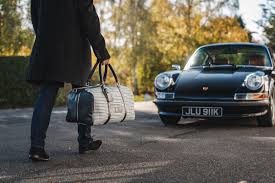 A person walking down a street next to a car