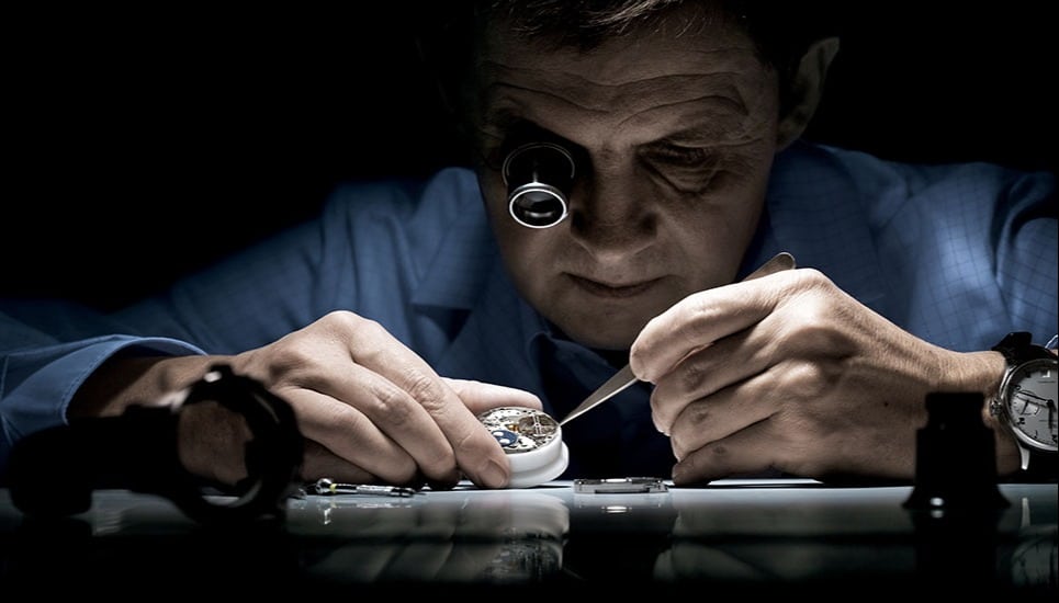 A man sitting at a table looking at a cell phone