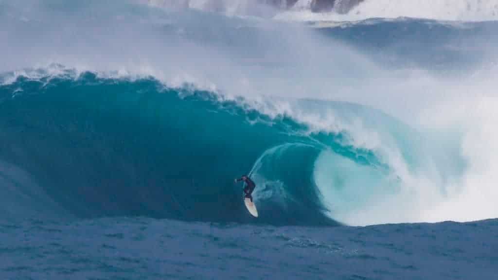 A man riding a wave on top of a body of water