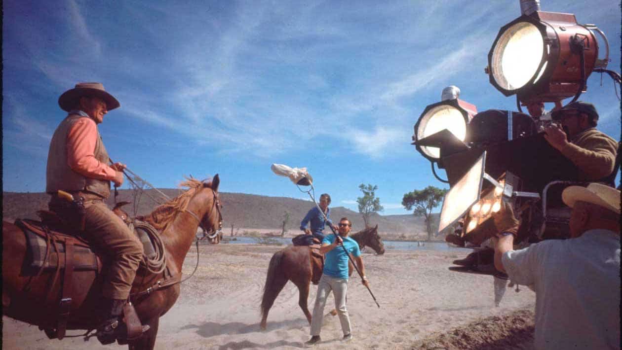 A group of people riding horses on a beach