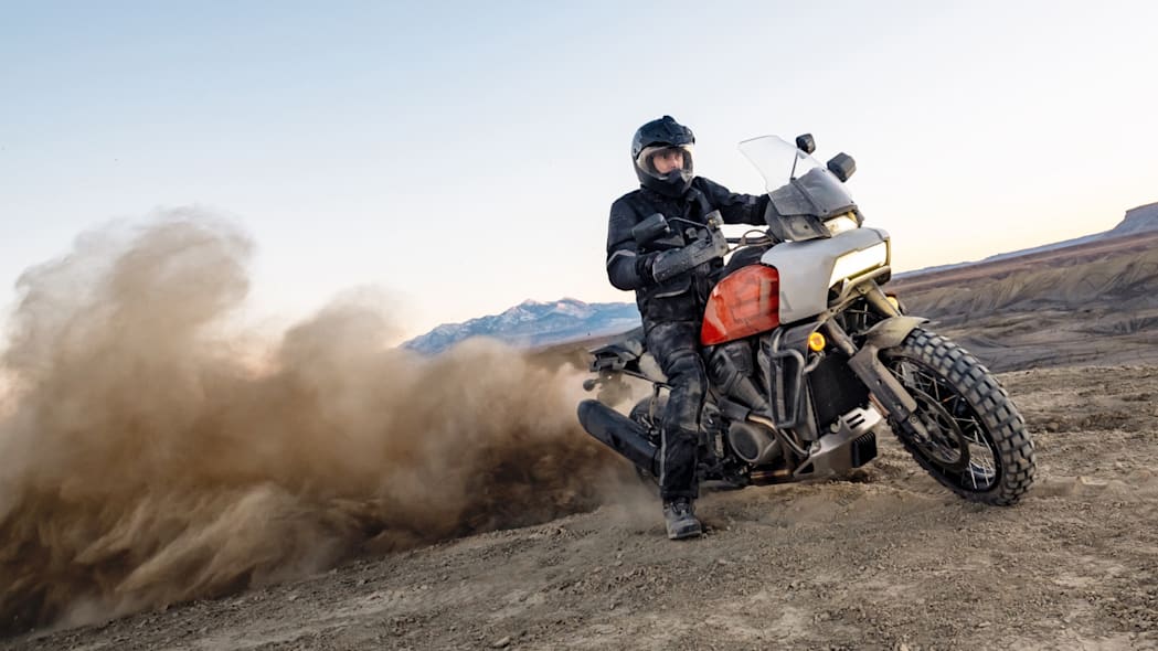 A man riding a motorcycle down a dirt road