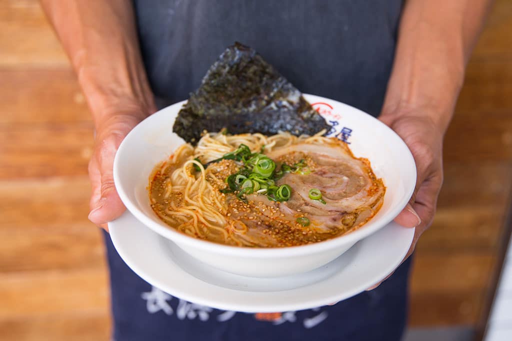 A person holding a plate of food on a table