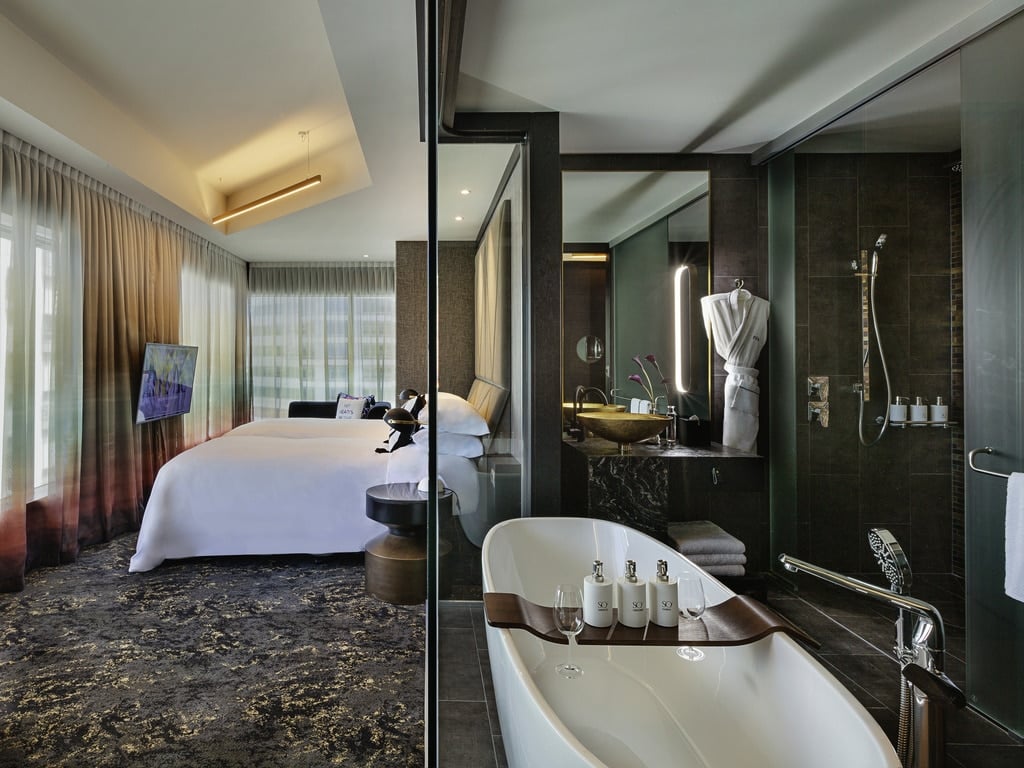 A hotel room with a sink and a mirror