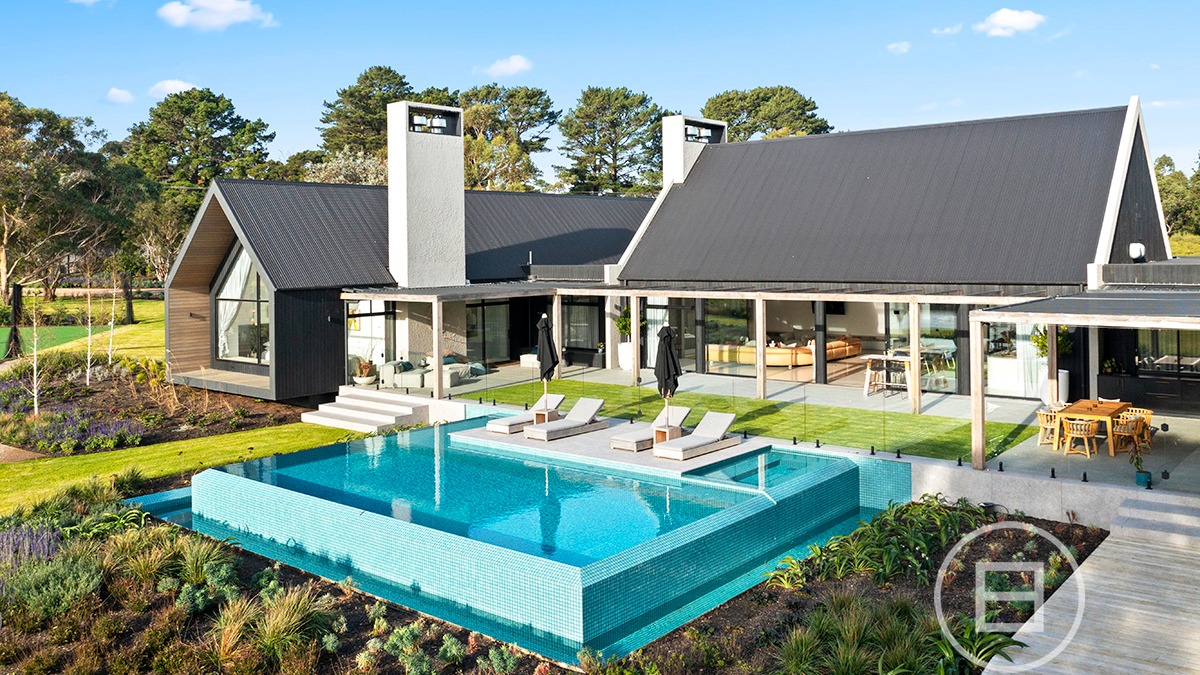 A house with a pool in front of a building