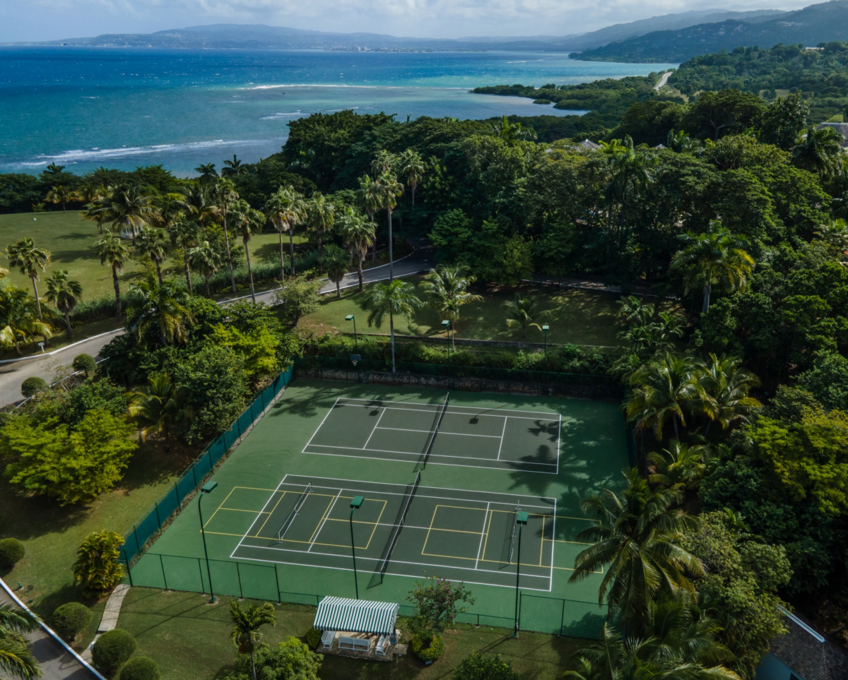 Tennis courts set in lush palms at Round Hill Hotel & Villas, Montego Bay, Jamaica