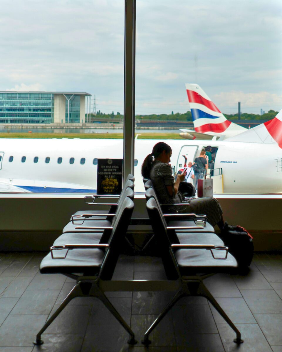 Woman sits in the departure lounge of the London airport